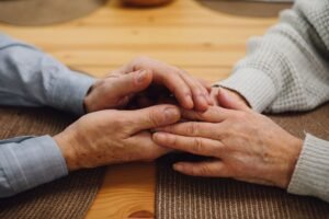 Comforting hands holding each other gently, representing healing after loss