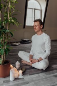 Person sitting cross-legged in quiet meditation practice, repeating a transcendental meditation mantra
