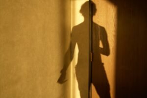 Shadow of man on hotel room door