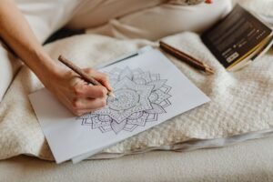 Hand coloring a mandala design with pencils, a relaxing meditative coloring page activity