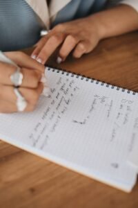Hand writing in a notebook, representing guided inner child worksheet exercises for emotional growth
