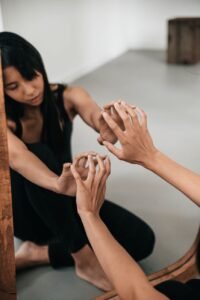 Two hands reaching toward a mirror reflection, symbolizing parts work therapy and self-understanding