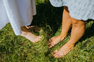 Bare feet standing in green grass, a simple grounding technique for calming the nervous system