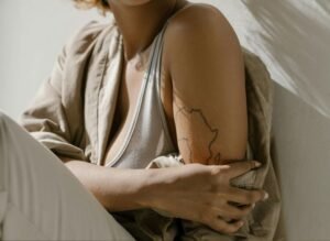 Close-up of an arm with a map-like tattoo, symbolizing the emotional map of the body