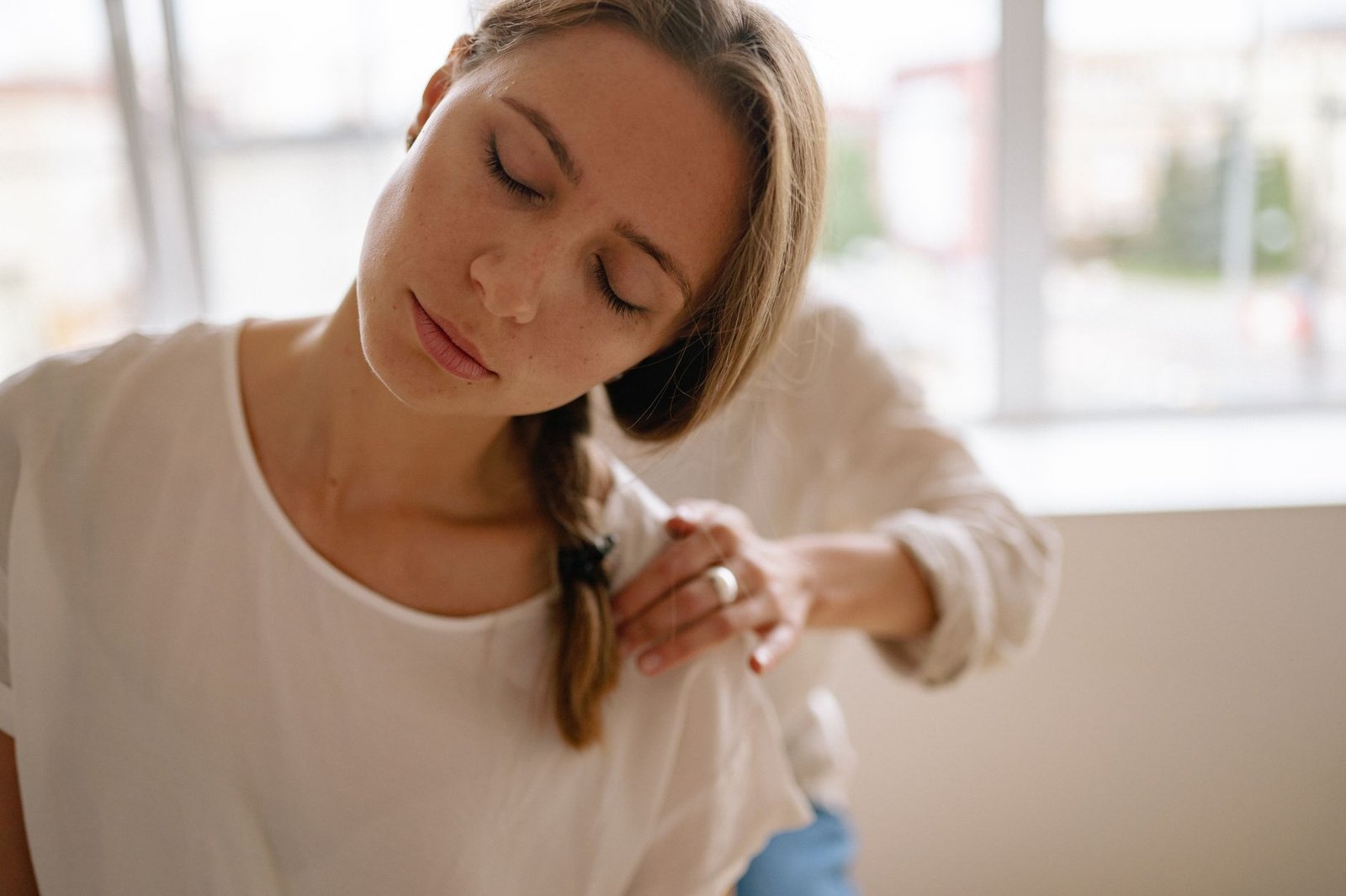 Woman with hand on her chest, eyes closed, practicing a somatic mind-body awareness exercise