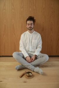 Man sitting cross-legged indoors in a quiet 15-minute mindfulness meditation practice