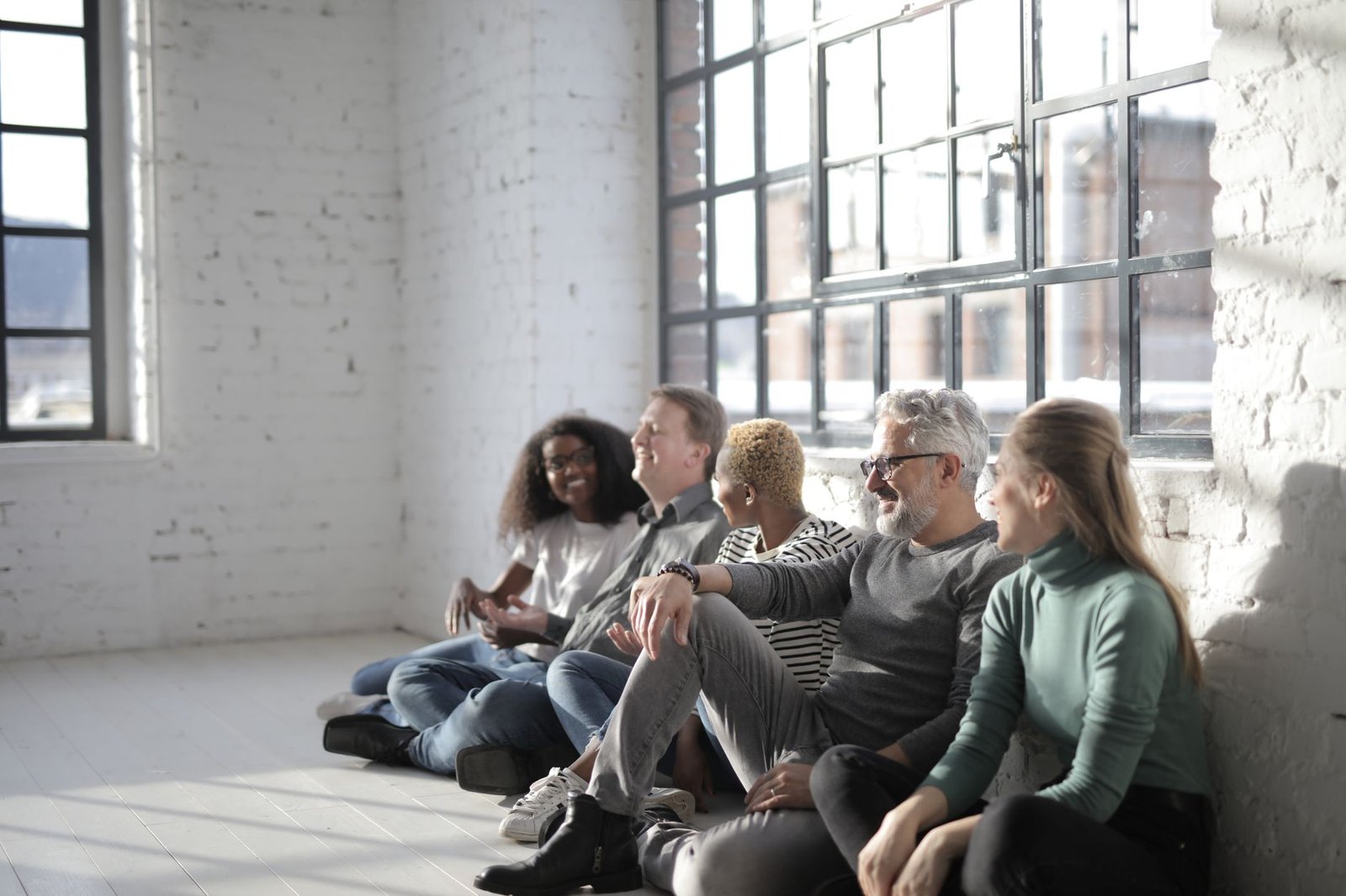 A small circling group sitting together in a relational healing sharing circle, practicing present-moment connection