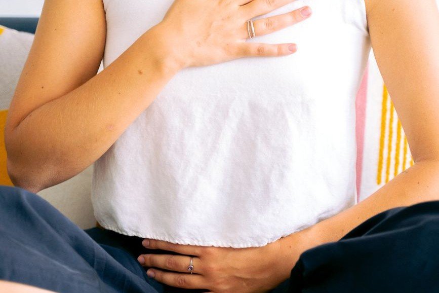 Woman with hand on chest, illustrating how we store emotions in the body
