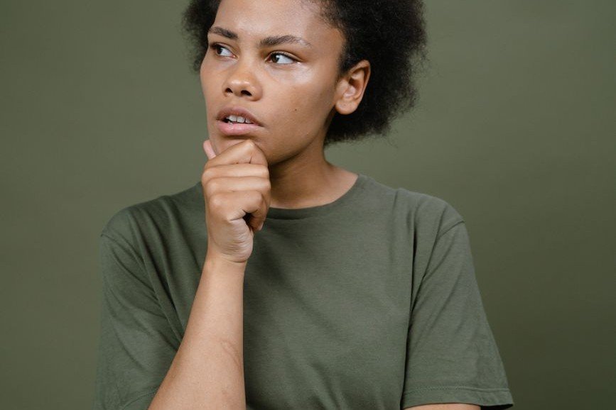 Woman with a thoughtful, questioning expression, illustrating hidden cognitive biases in decision-making