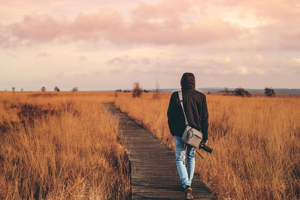 Person walking an open path toward the horizon, representing the journey of navigating vulnerability
